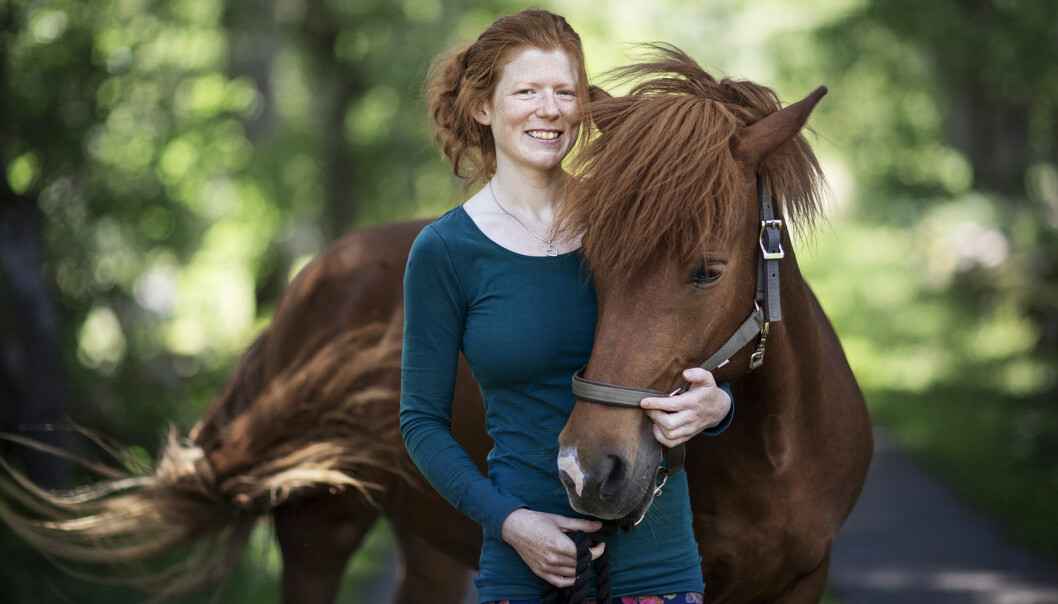 Elin håller om en av sina hästar