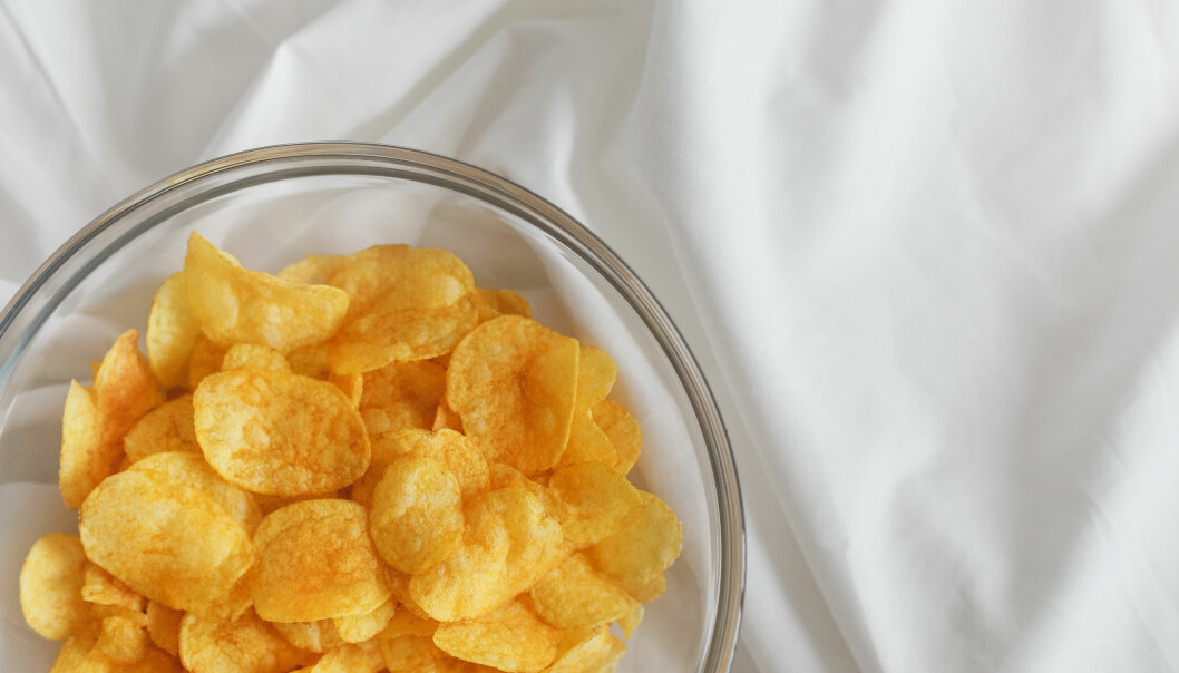 En glasskål med chips står på ett vitt lakan.