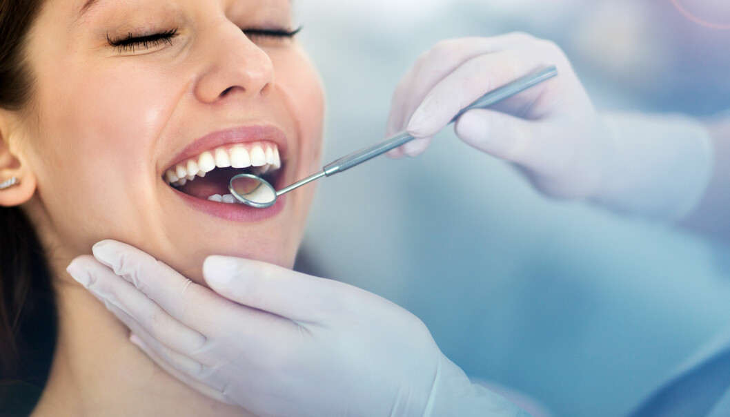 Tandsten måste tas bort av en tandläkare eller tandhygienist. En kvinna är hos tandläkaren som kontrollerar hennes tänder för plack och tandsten med en spegel.