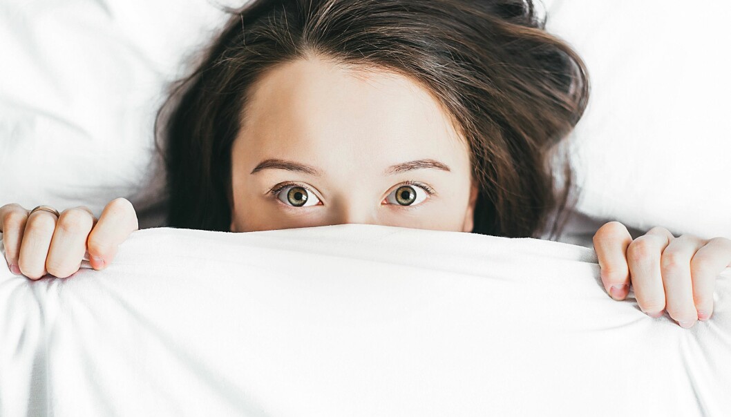 En kvinna har problem med att somna med täcket över halva ansiktet.
