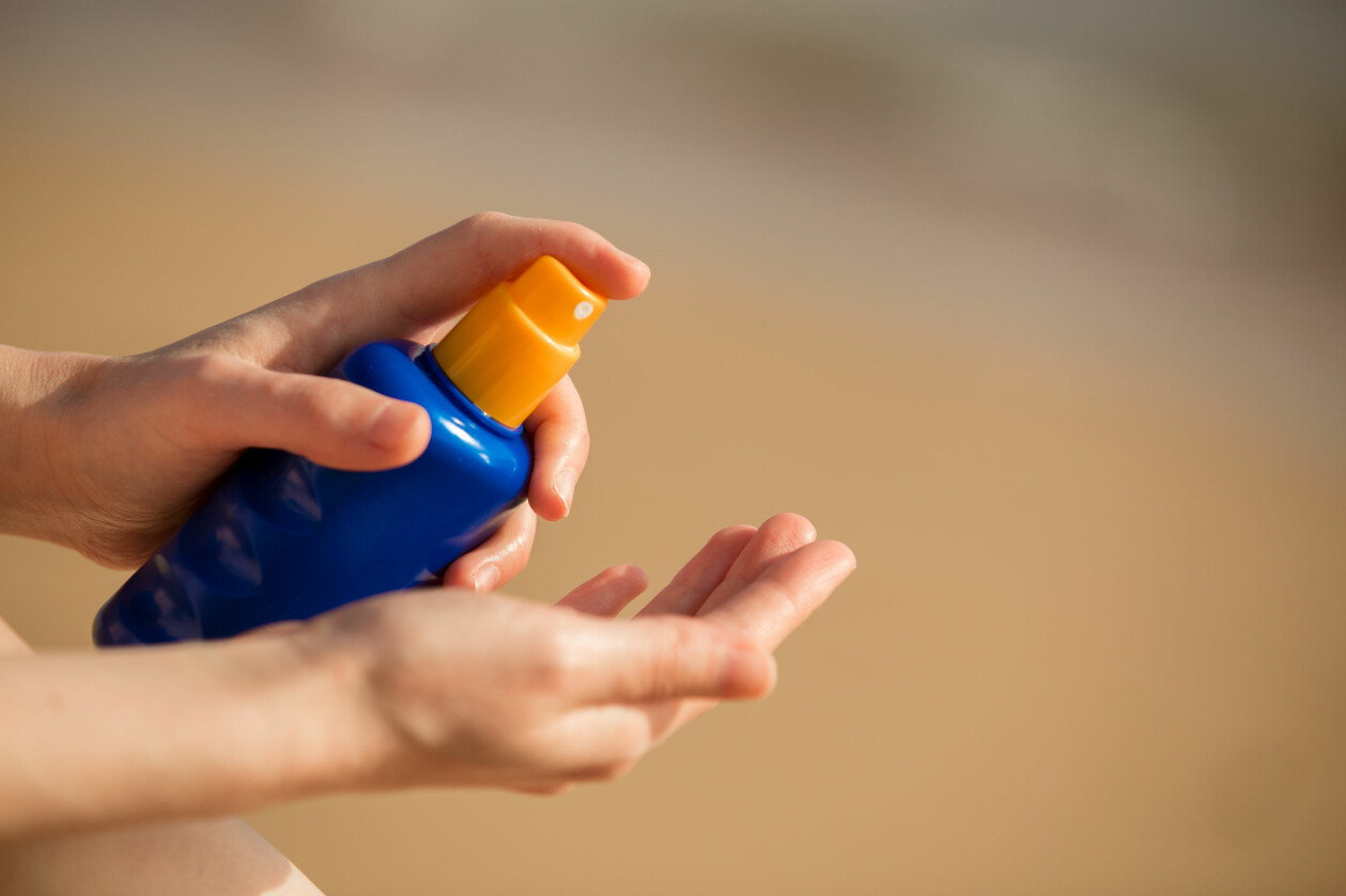 <i>Foto: TT/Shutterstock</i> En kvinna sprayar solskydd på sin hand.