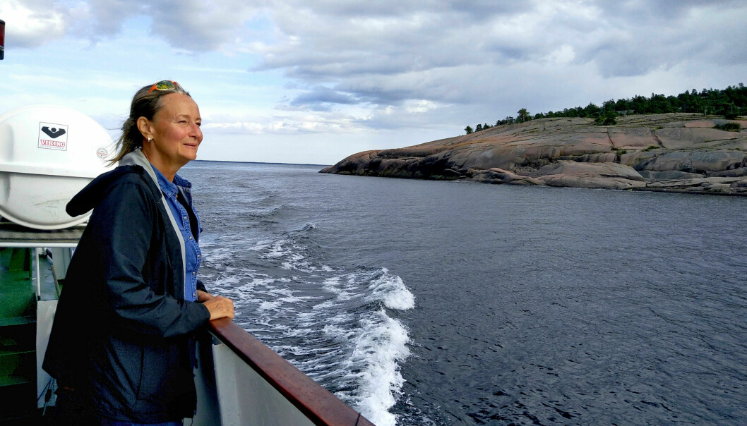 En kvinna står ute på däck på en båt.