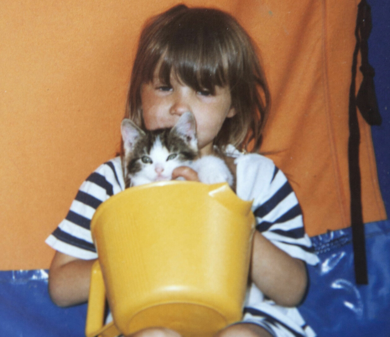 Ingen tog hand om Sofie när hon var liten. En privat bild av Sofie som litet barn, med en katt i famnen.