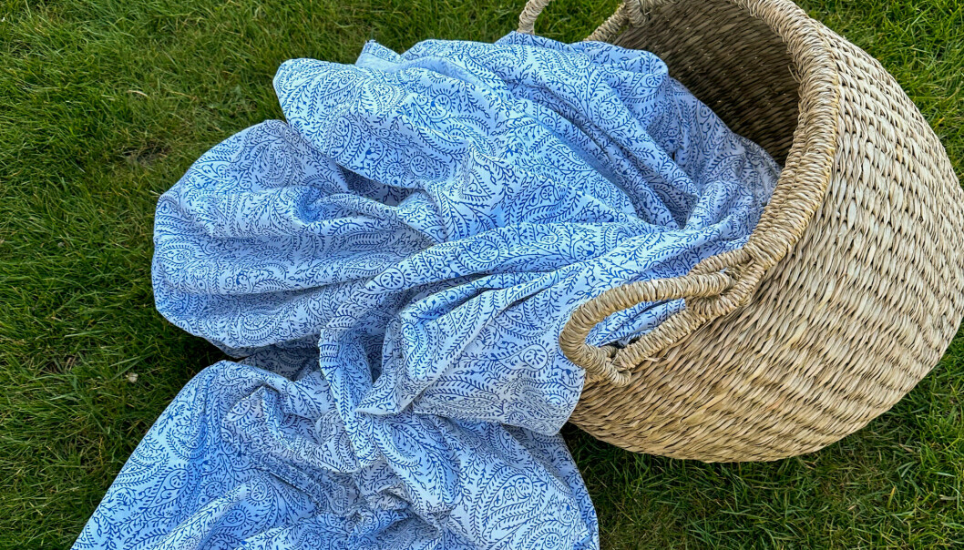 En rottingkorg med tyg i blått och vitt