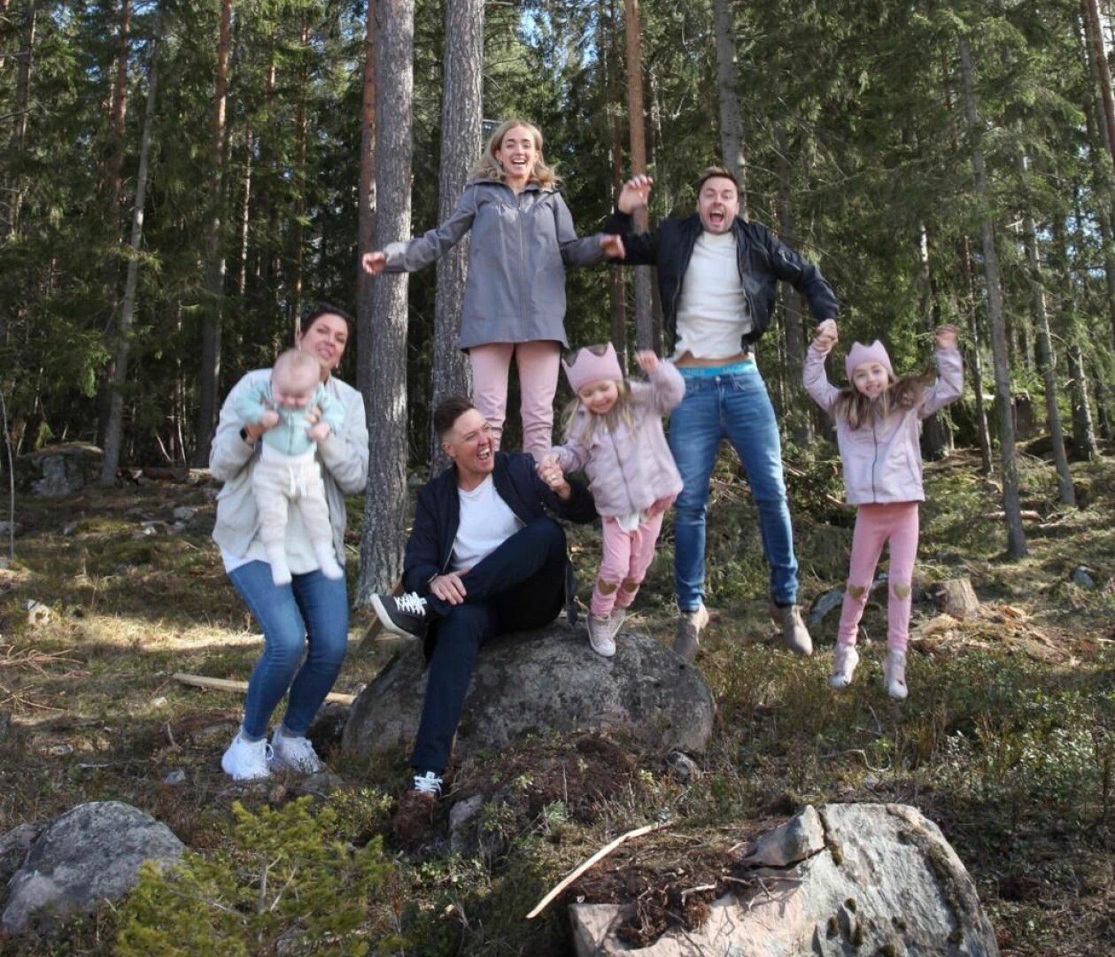 Gänget känner sig som en enda stor och lycklig familj. Ett gäng vuxna pch barn hoppar upp i luften, inne i skogen.