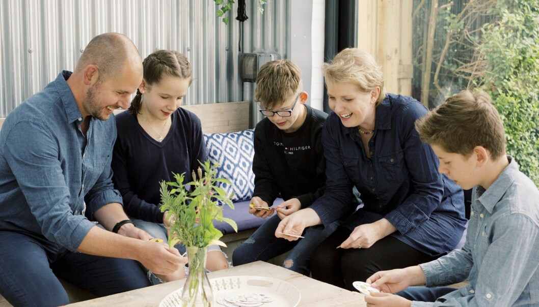 Alex tvillingbror Josh är idag 13 år. När han var 15 månader fick Clare och Rob ytterligare ett tvillingpar. Foto: Charlie Hopkinson Familjen Mackintosh samlad runt ett bord där de spelar kort och ser glada ut.