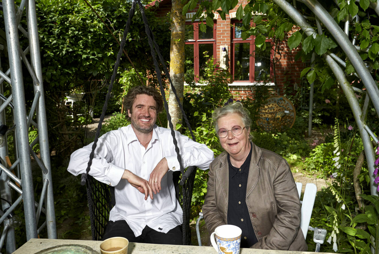 Maggan och Peter sitter i trädgården med kaffe framför sig.