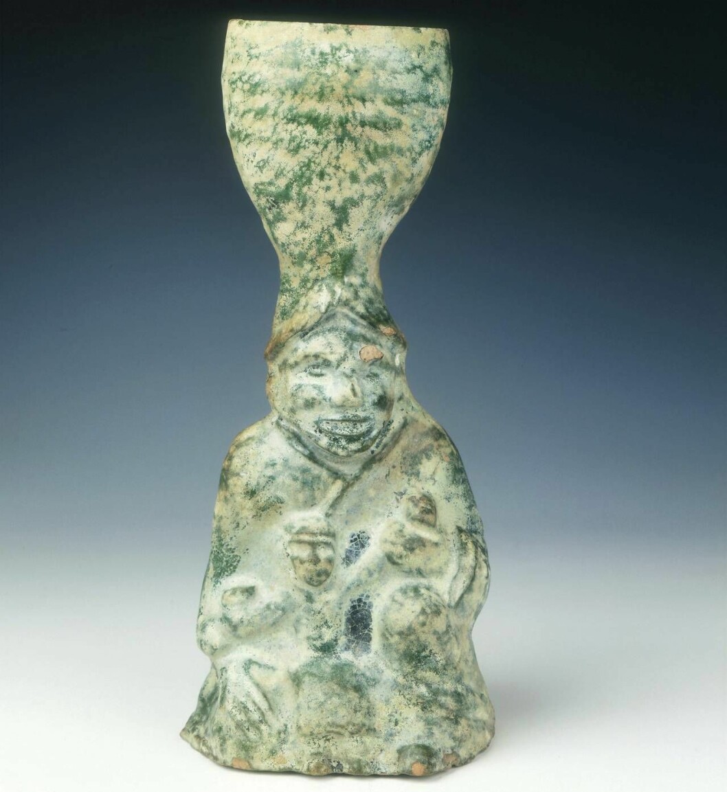 Tvåtusenårig kinesisk gravfigur från Han-dynastin i form av en ljusstake föreställande en man med ett spädbarn. Kinesisk gravfigur