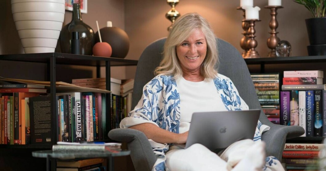 Författaren Åsa Hellberg sitter i en stol med datorn i knät 