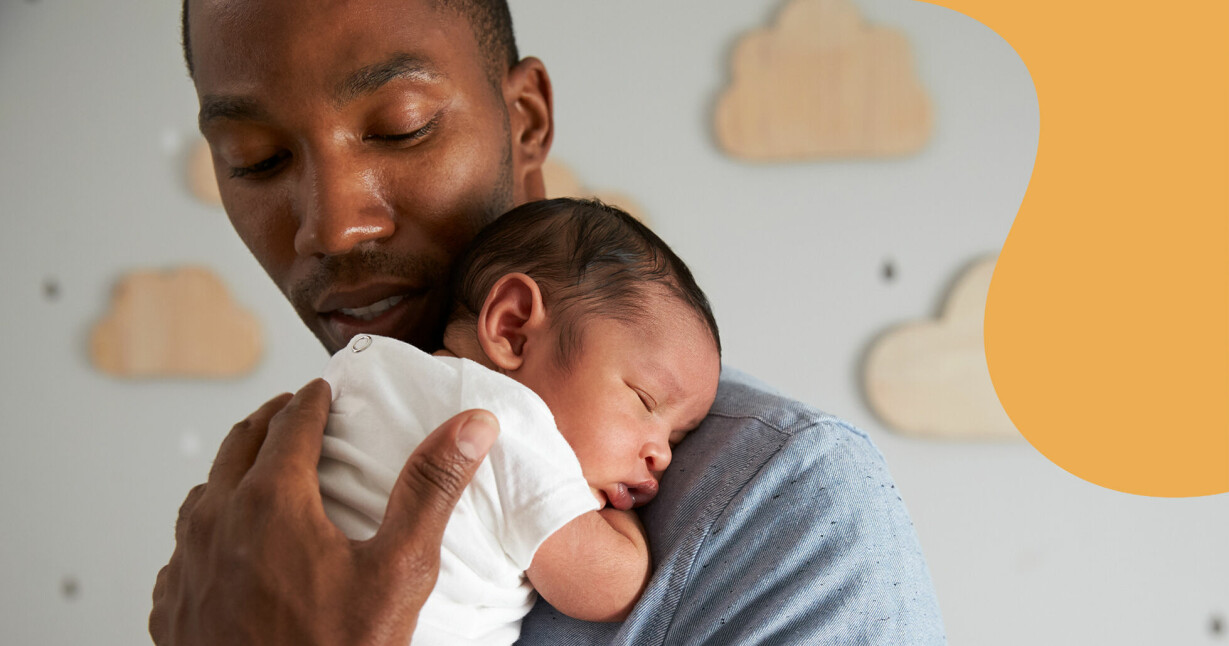 Nybliven pappa håller sin sovande bebis mot bröstet.