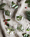 Genomskinliga julgranskulor fyllda med kvistar.