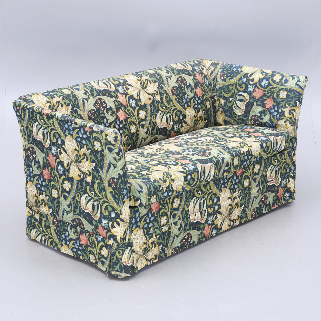 <span class=" italic" data-lab-italic_desktop="italic">Golden Lil</span>y ritades 1899 av John Henry Dearle som avancerade från butiksbiträde till konstnärlig ledare för Morris & Co. Soffan i en mörkare variant av mönstret fick ett värde på 1 800 kronor hos Växjö Auktionskammare.
