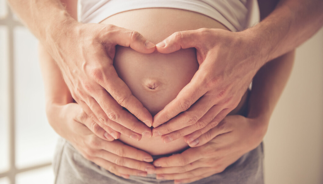 Många kvinnor känner en stress över att skaffa barn och bilda familj. En kvinna och en man håller sina händer runt kvinnans gravida mage.