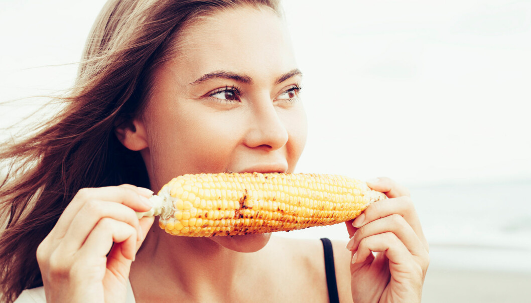 Kvinna äter majs