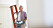 En målare håller i en röd stege och en färgtråg
