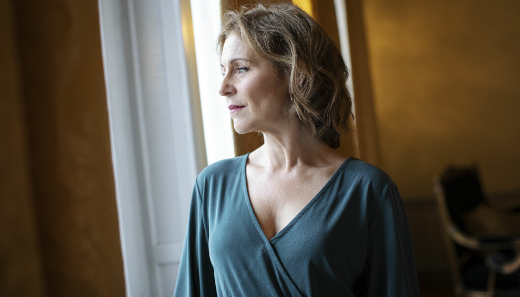 Helen Sjöholm tittar ut genom ett fönster inne på Grand hotel i Stockholm.