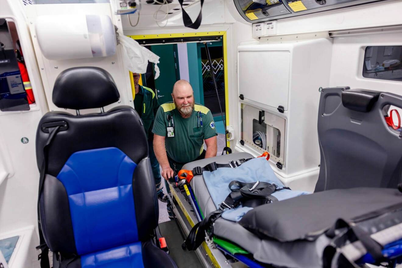 Ambulanssjuksköterskan Andreas tar ut en brits från ambulansen.