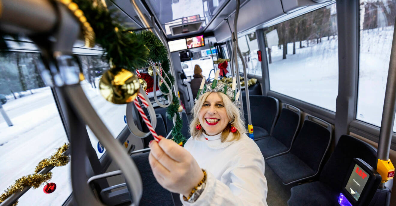 Anette Glad har på sig luciakläder och visar upp sin julpyntade buss.
