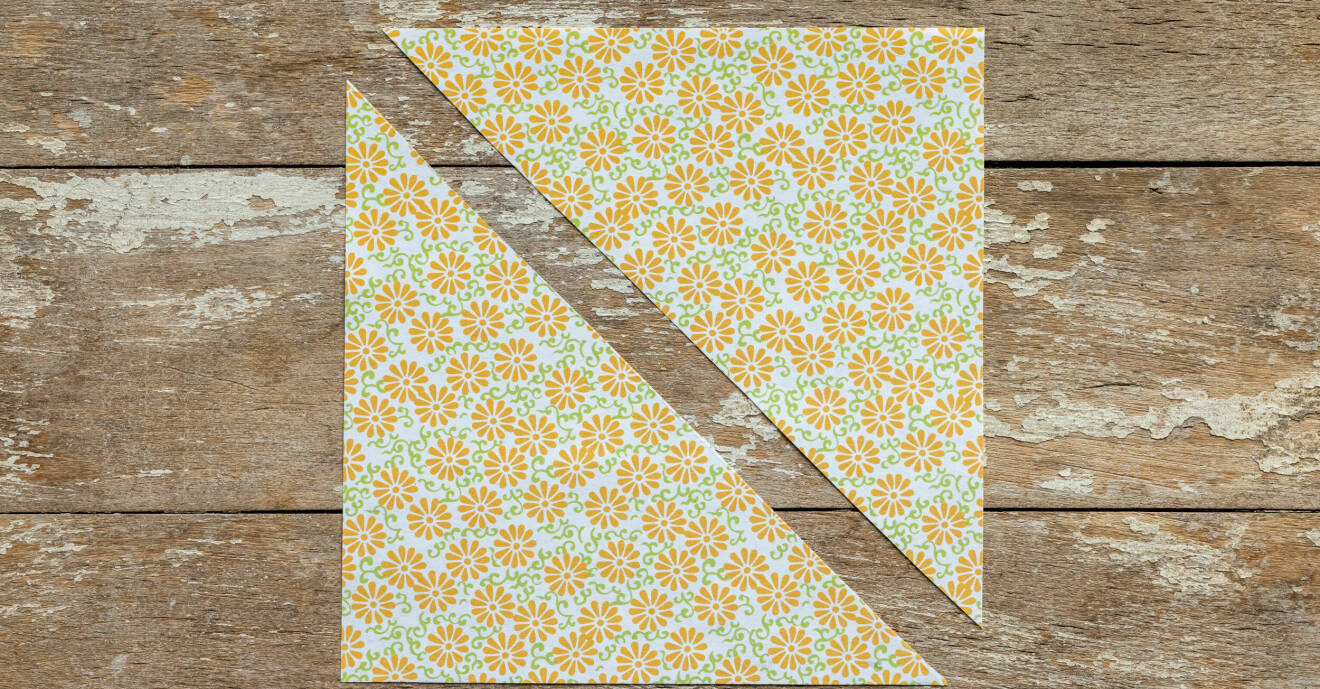 Två trianglar av mönstrat papper med gula blommor
