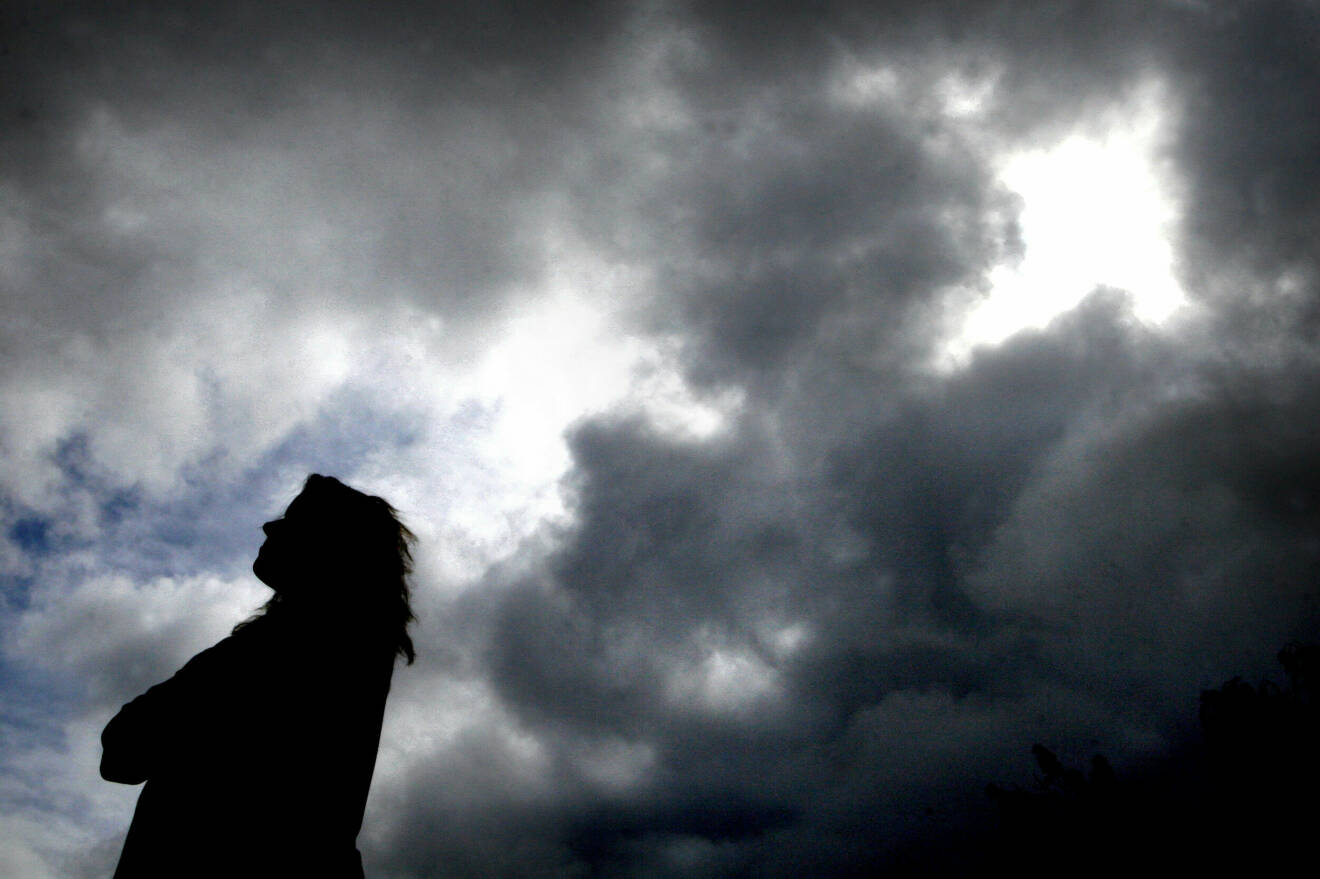 En anonym kvinna mot en molnig bakgrund.