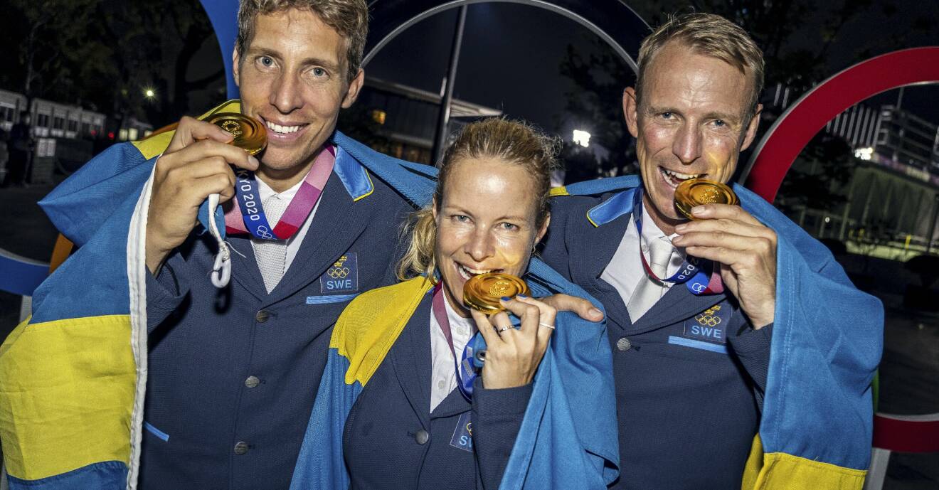 Henrik von Eckerman, Malin Baryard och Peder Fredricson med svenska flaggan och sina guldmedaljer i OS i Tokyo 2021.