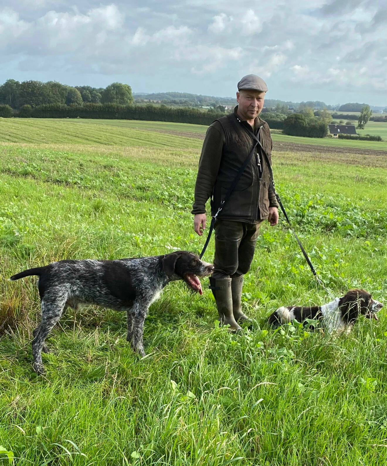 Jens Erik ute i naturen med två hundar.