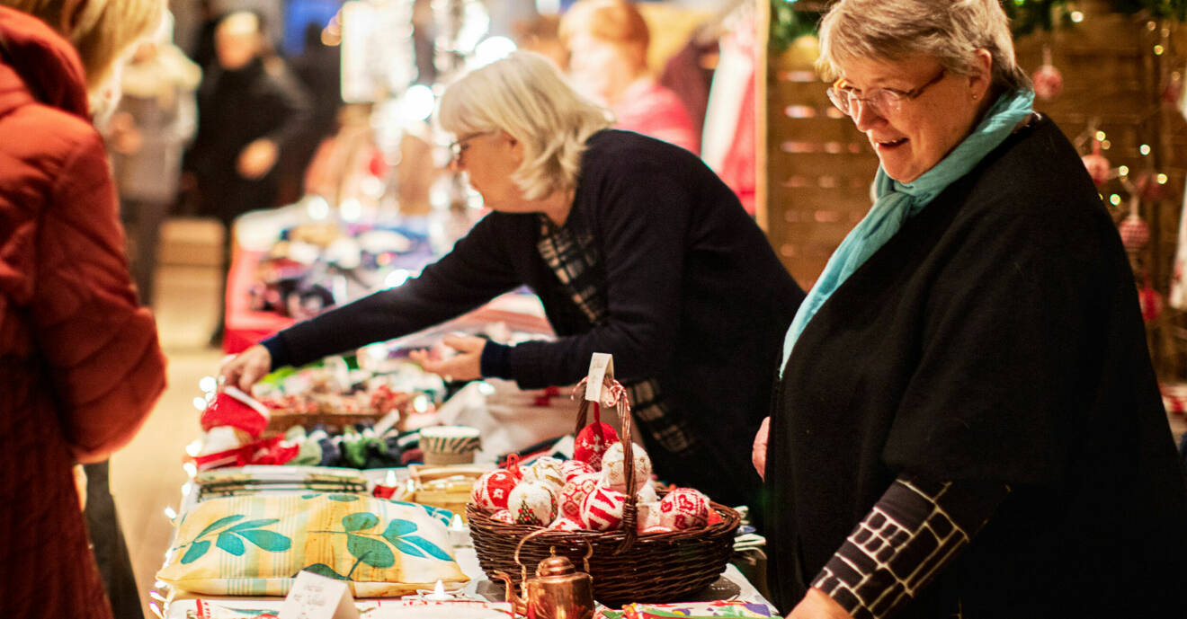Marianne och Birgitta säjer hantverk på julmarknad.