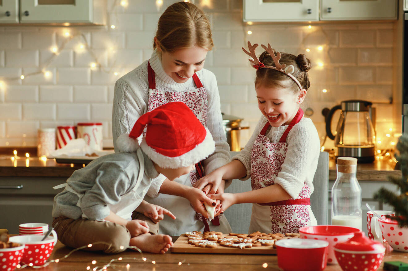 En familj, mamma och två barn som julbakar i köket.