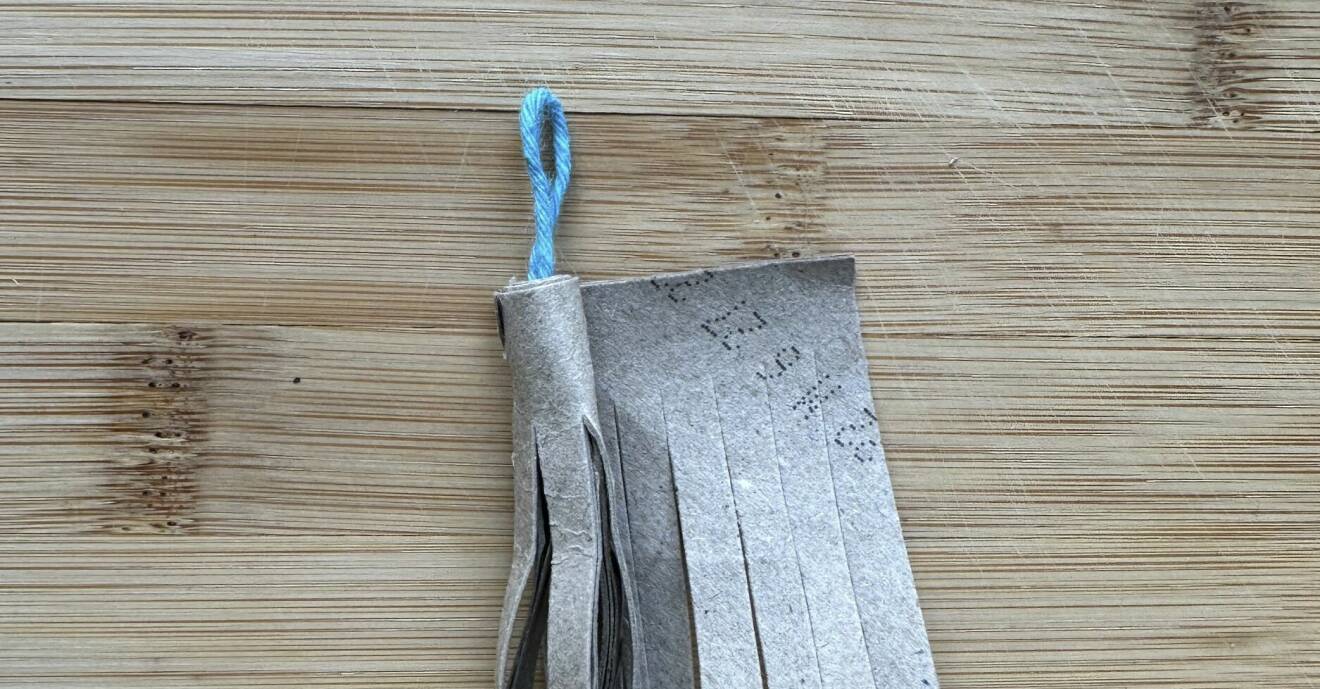 Hårt papper tvinnas runt en garnögla