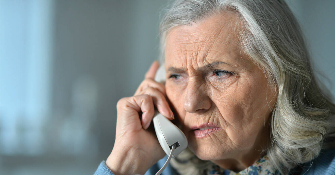 Äldre kvinna får ett telefonsamtal.