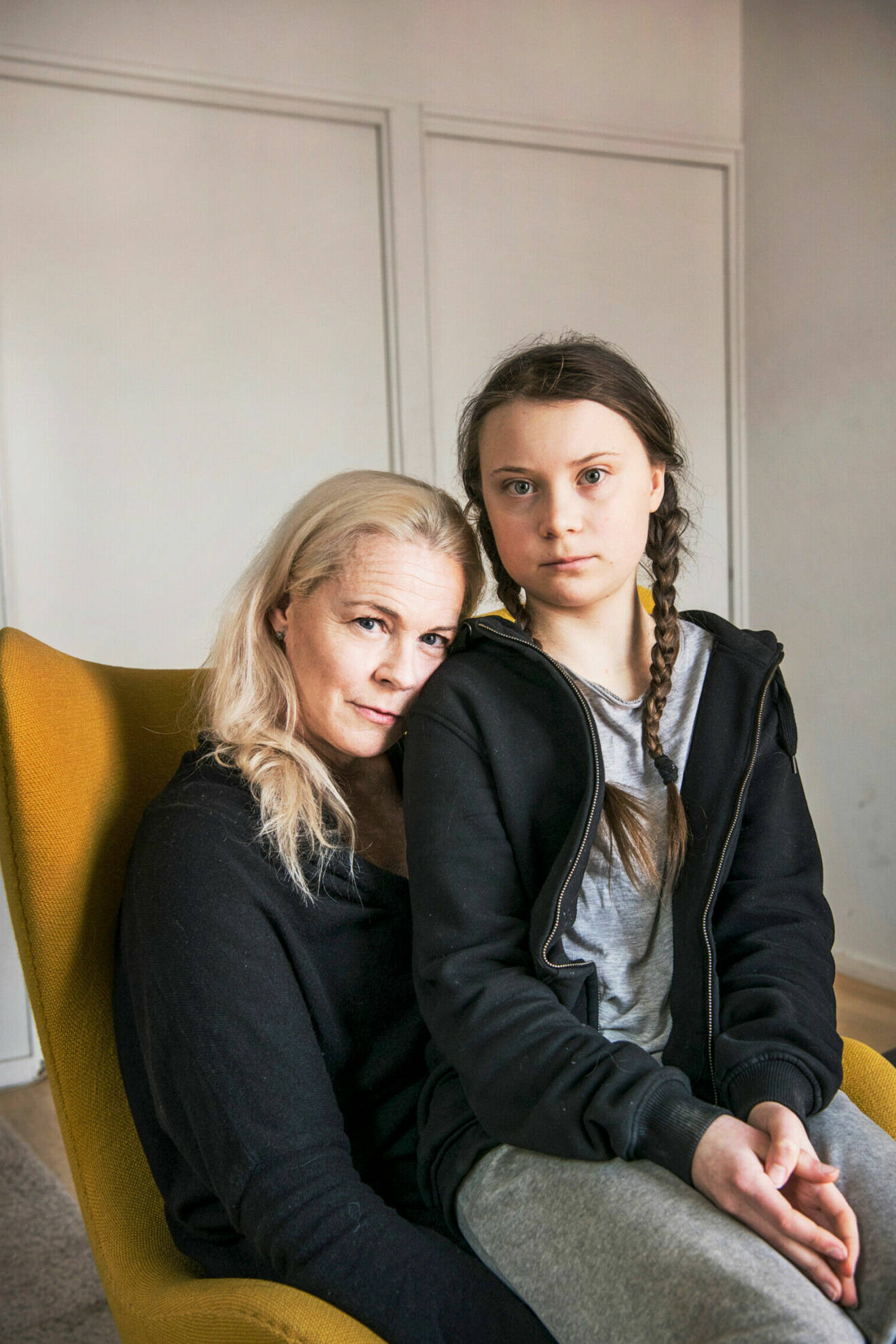 Malena Ernman med dottern Greta Thunberg i knat i en fatolj.