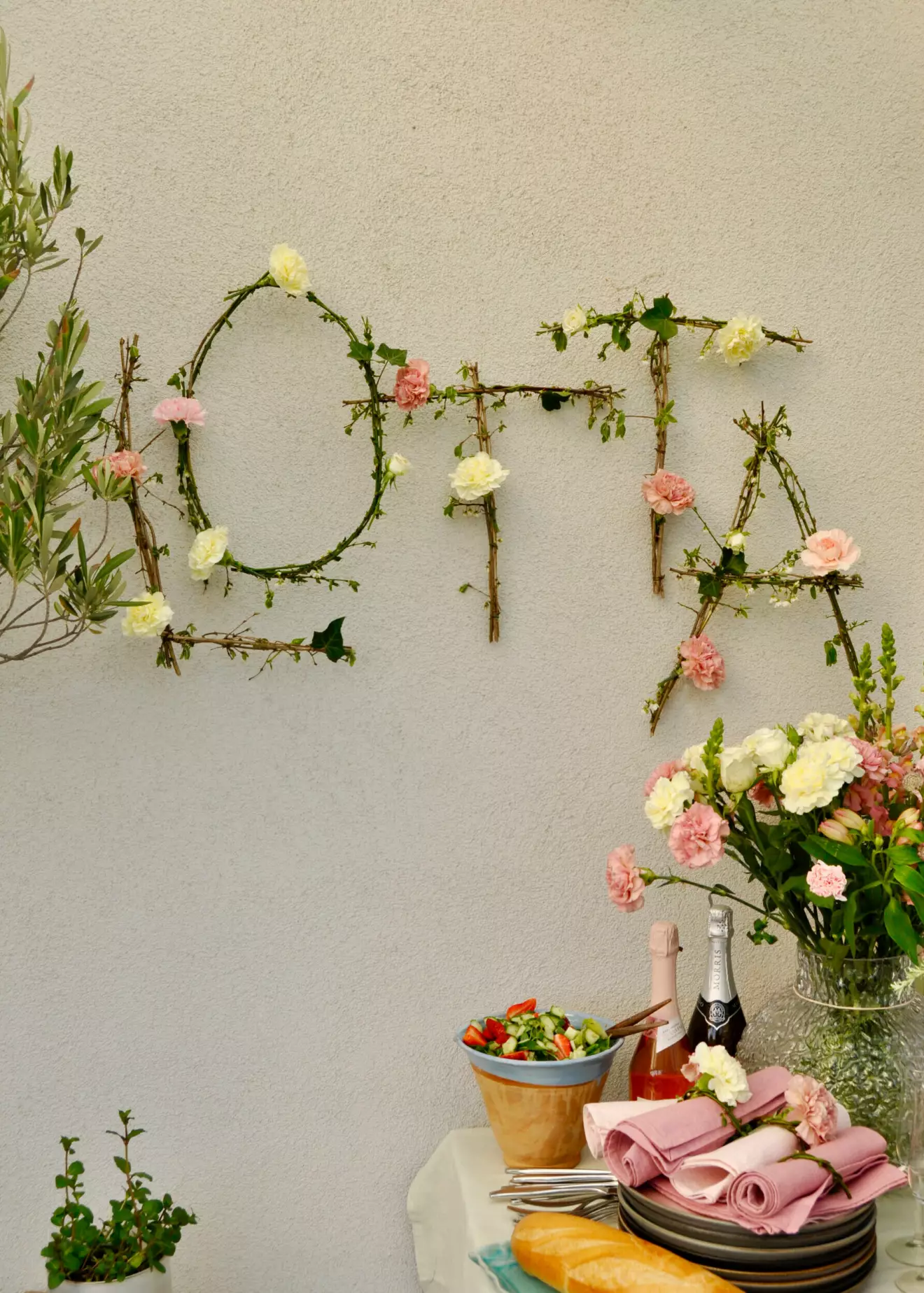 Blomsterbokstäver hänger på en vägg.