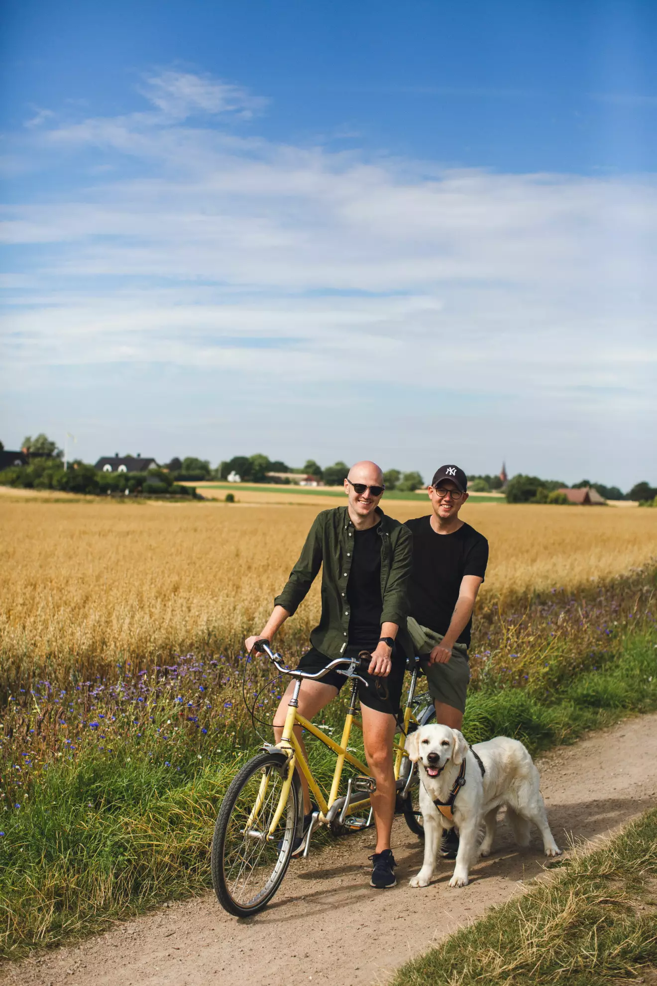 Marcus och Johan med en tandemcykel och hunden Inez bredvid.