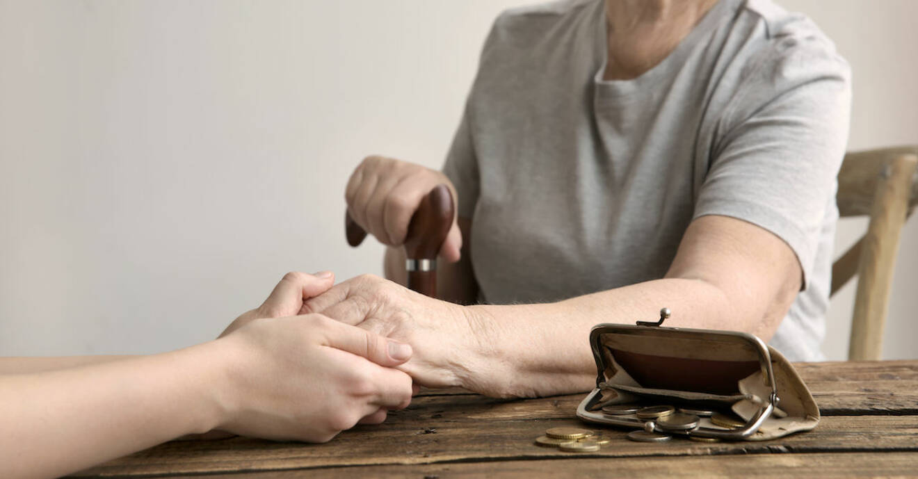 Yngre kvinna håller äldre kvinnas hand.