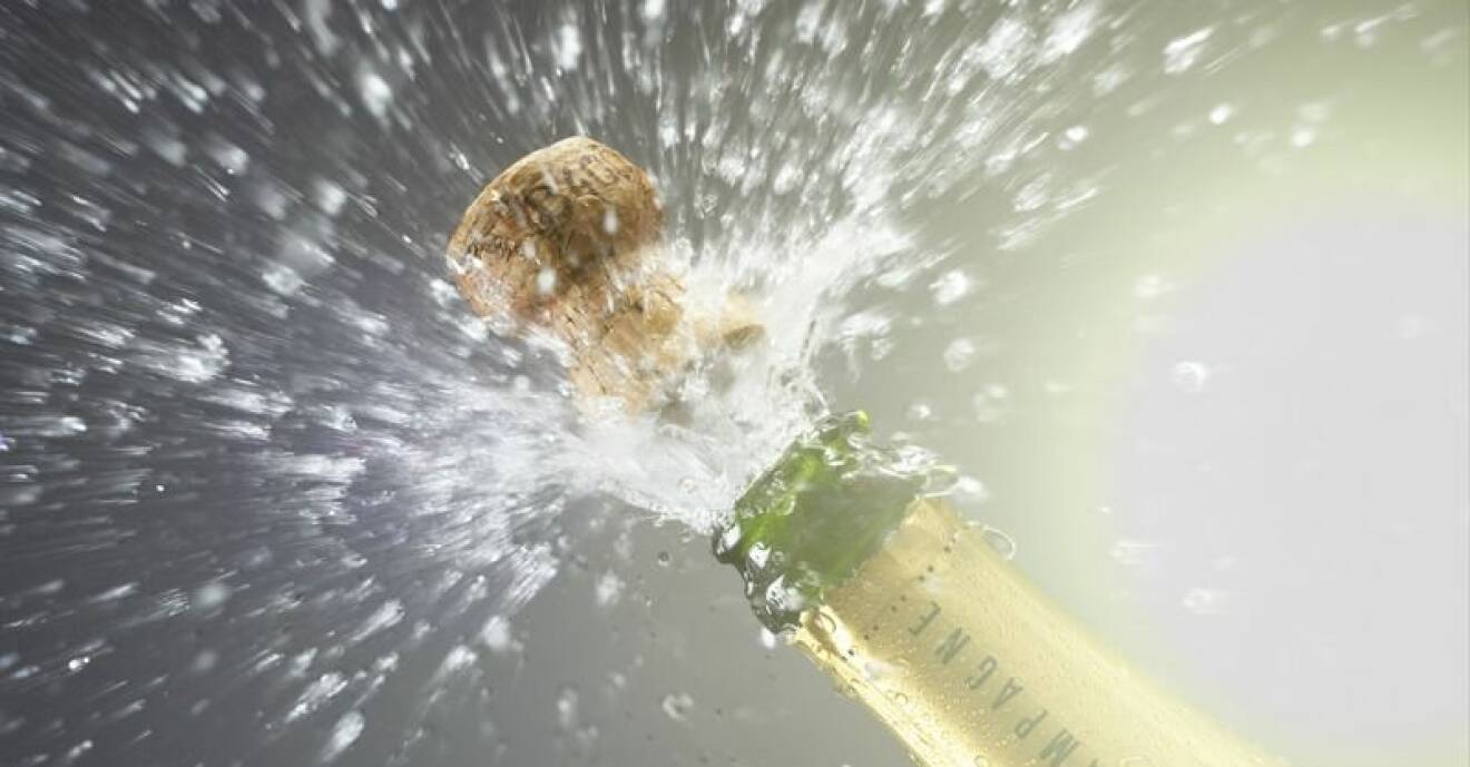 En champagnekork flyger ur flaskan.