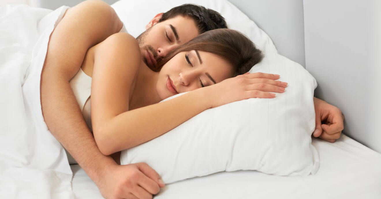 Kvinna och man sover i en säng.