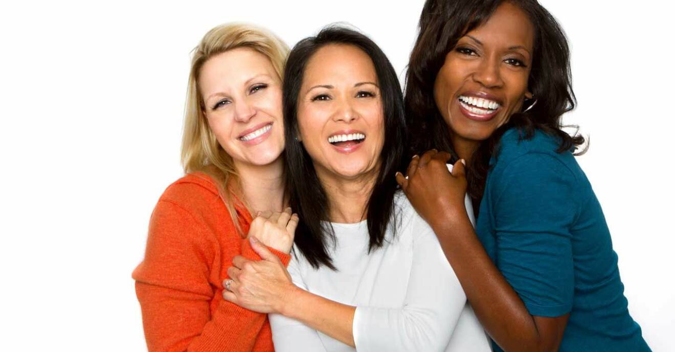 Tre kvinnor ler och har trevligt ihop.