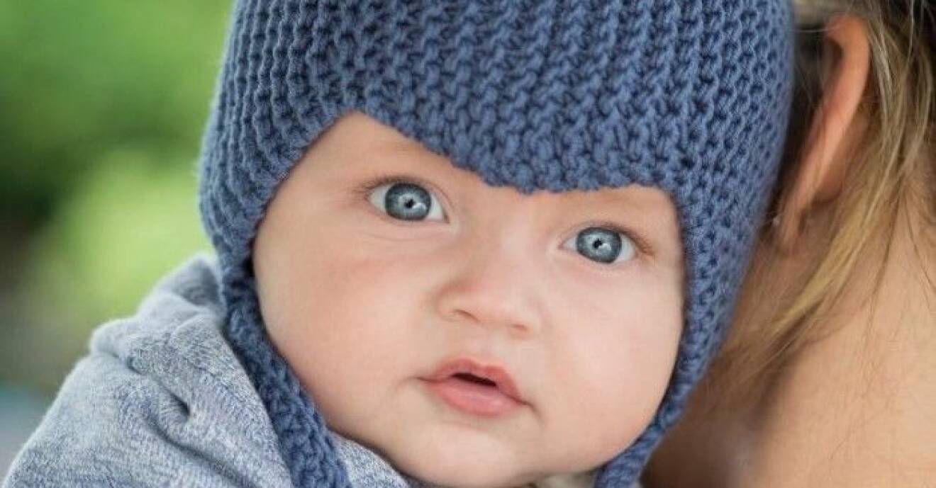 Baby i stickad blå mössa