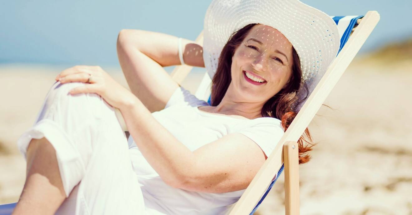 Kvinna i solstol på stranden
