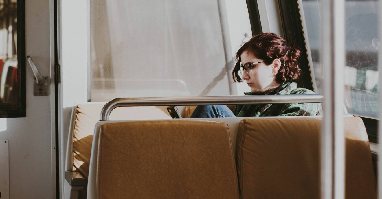 En kvinna sitter på ett tåg.