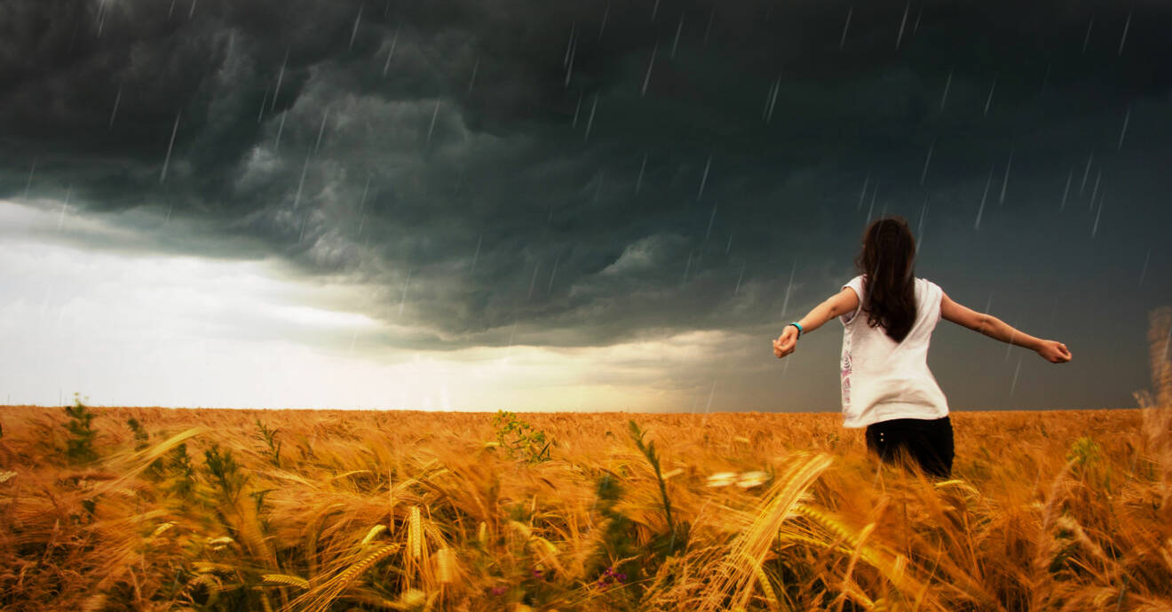 Kvinna på fält med stormig himmel