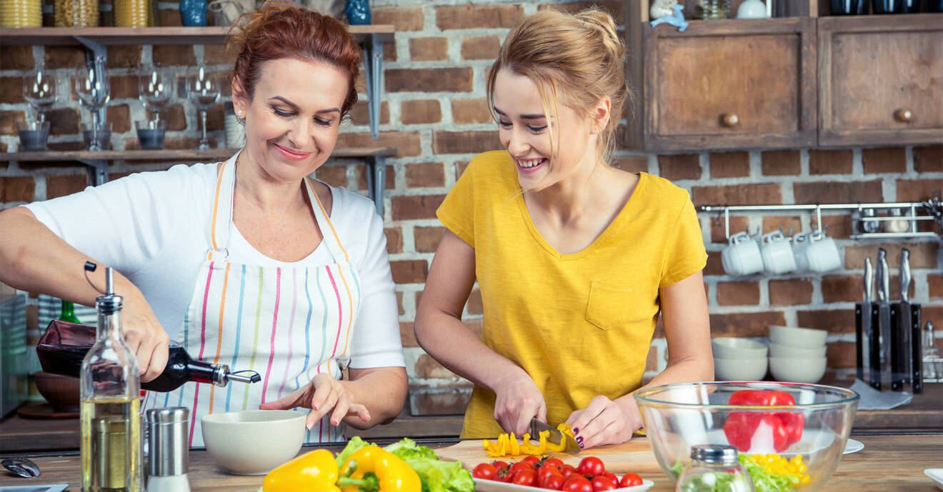 En mamma och dotter som lagar vegetarisk mat tillsammans.