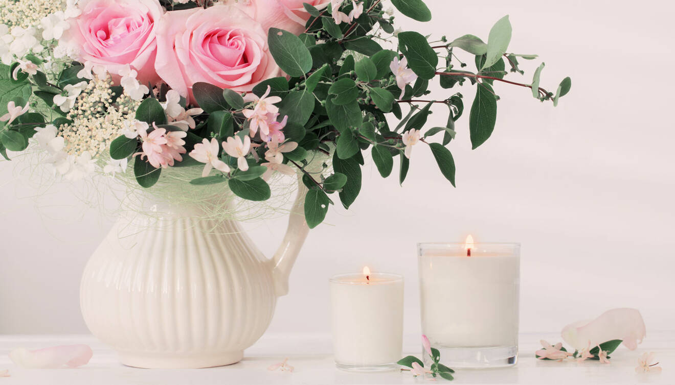 Doftljus och vacker blombukett på vitt bord