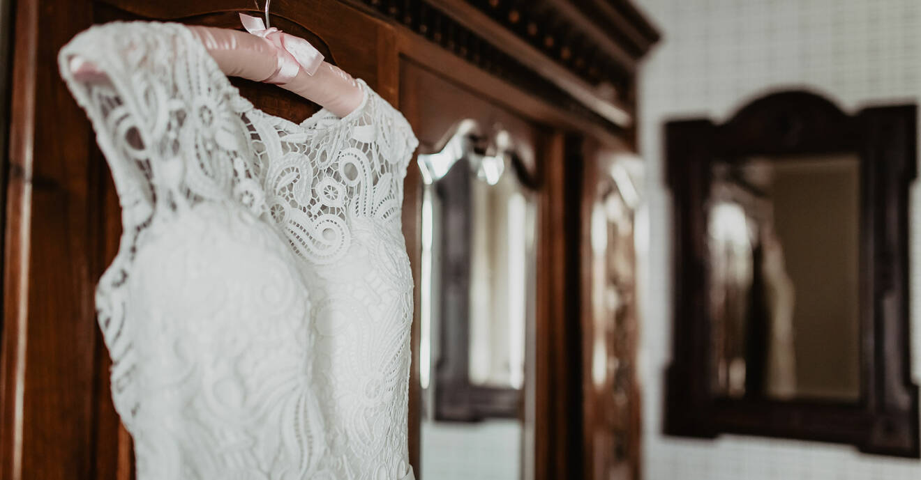 Brudklänning hänger utanför garderob