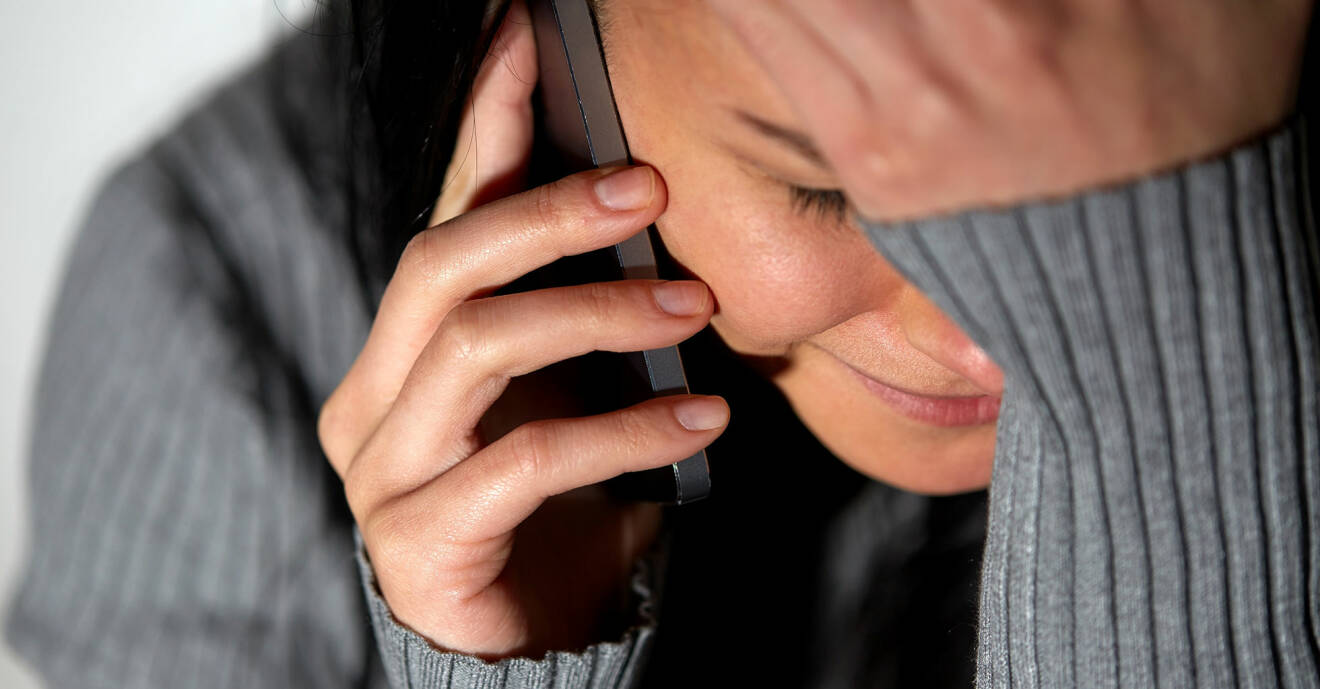 Kvinna med en telefon i handen gråter
