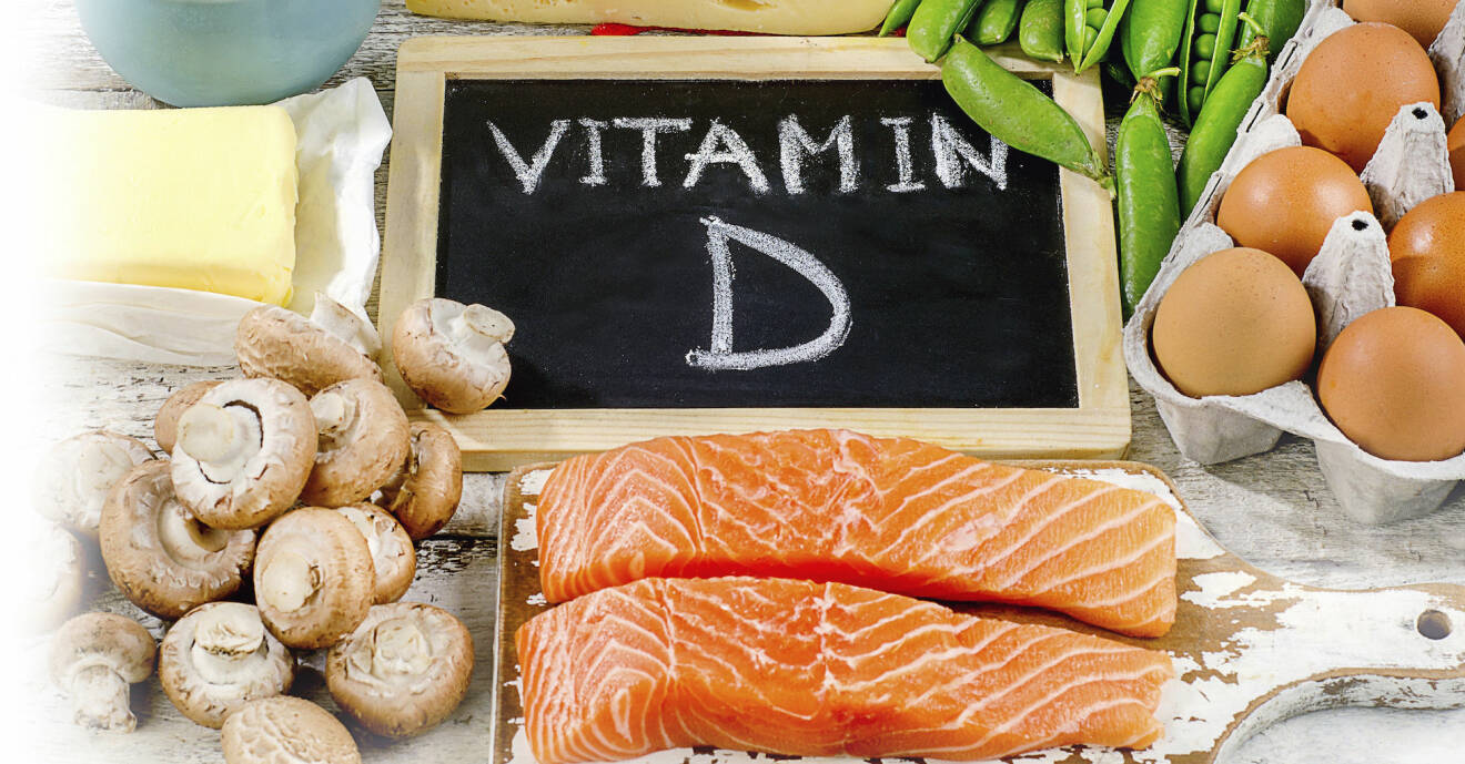 D-vitaminrik mat ligger på ett bord. I bakgrunden syns en skylt med texten ”Vitamin D”