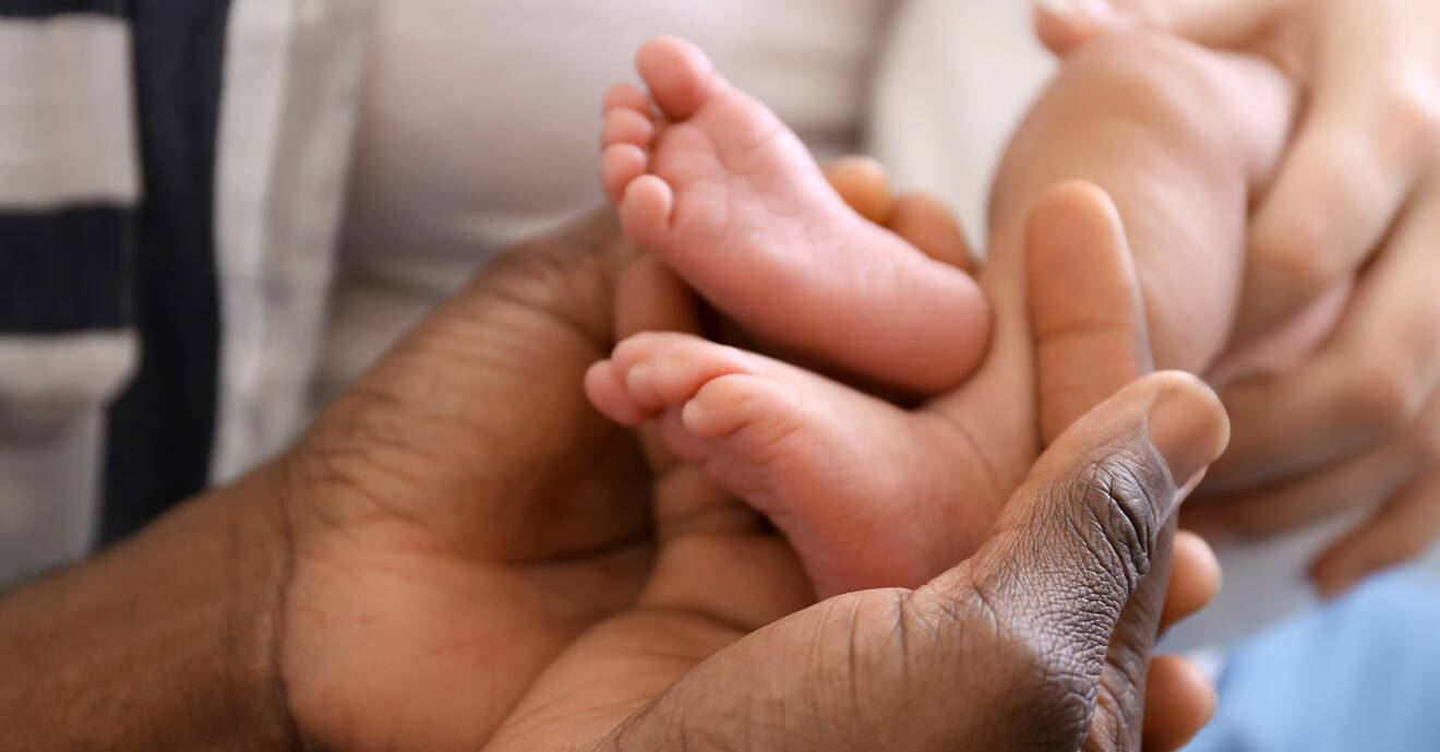 Kvinna gosar med ett spädbarns fötter