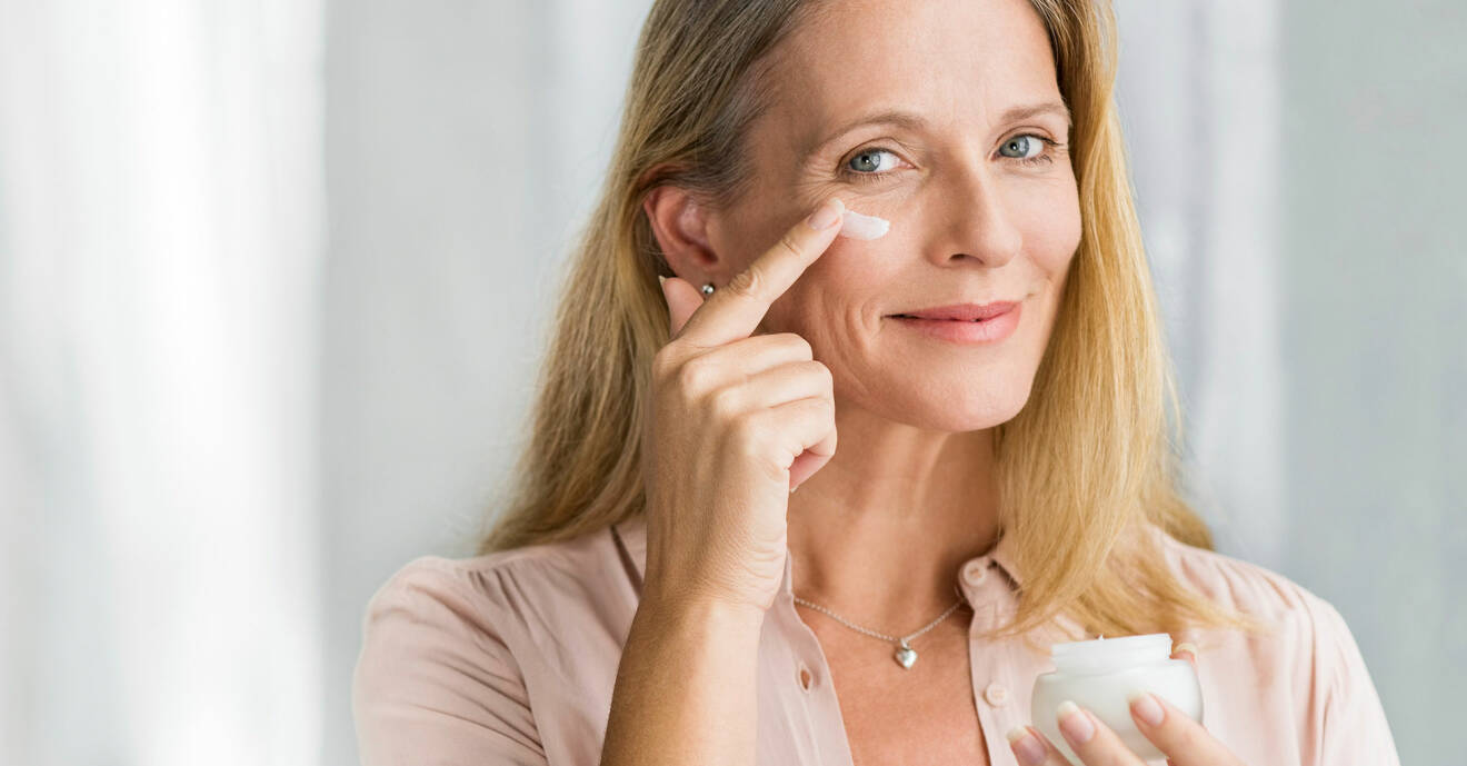 Kvinna smörjer på ögoncreme för att lindra ögonbesvär.