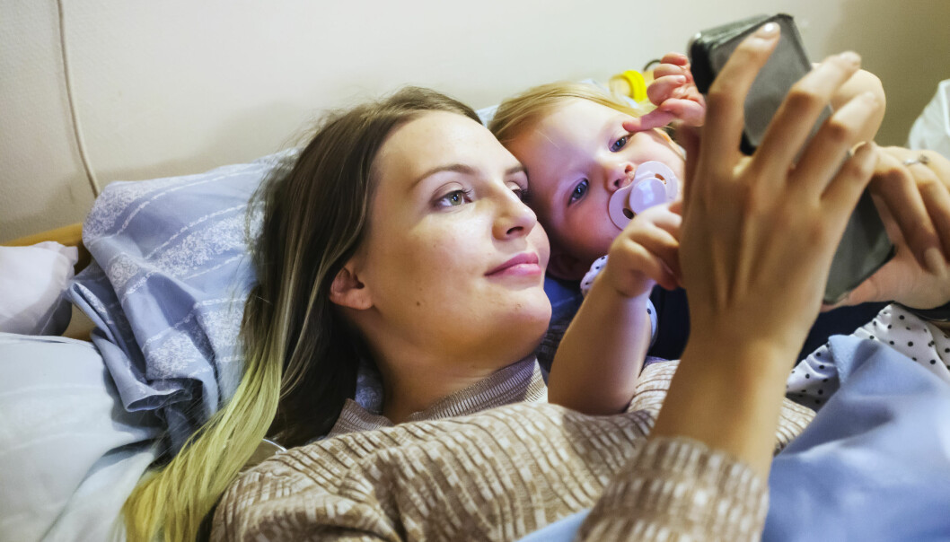 På helgerna får Mindie sova över hos sin mamma på korttidsboendet. Åsa Brännmark, som är bunden till sängen, tittar på telefonen med dottern Mindie.