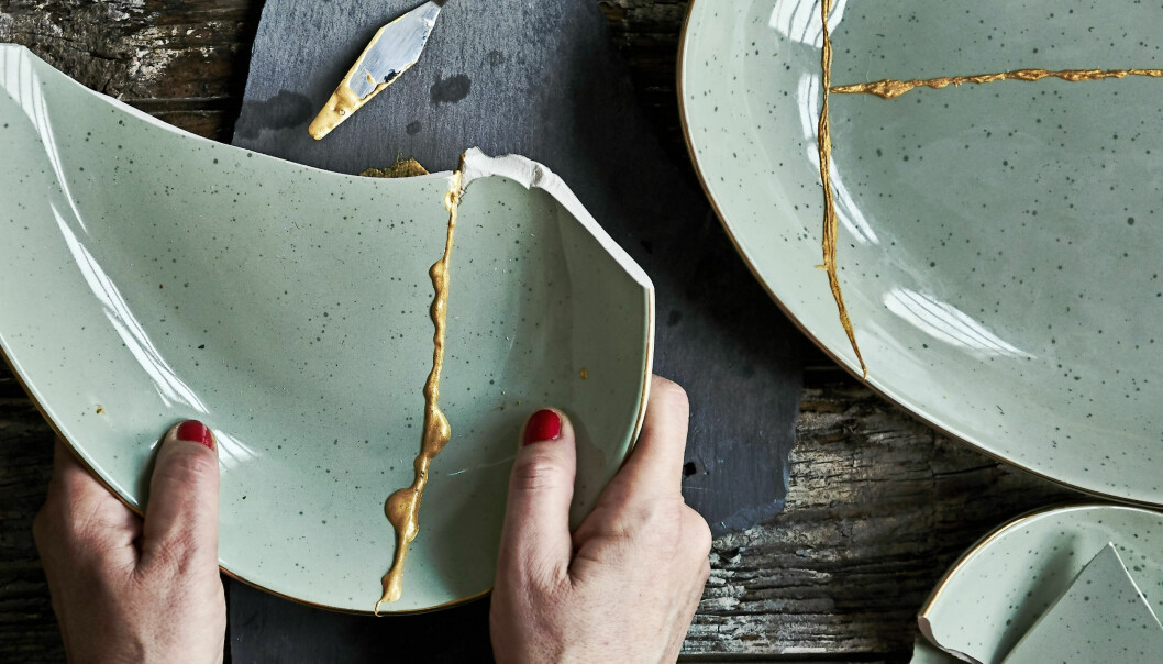 Kvinna pressar i hop två porslinsdelar mot varandra för att gå dem att fastna enligt metoden kintsugi.